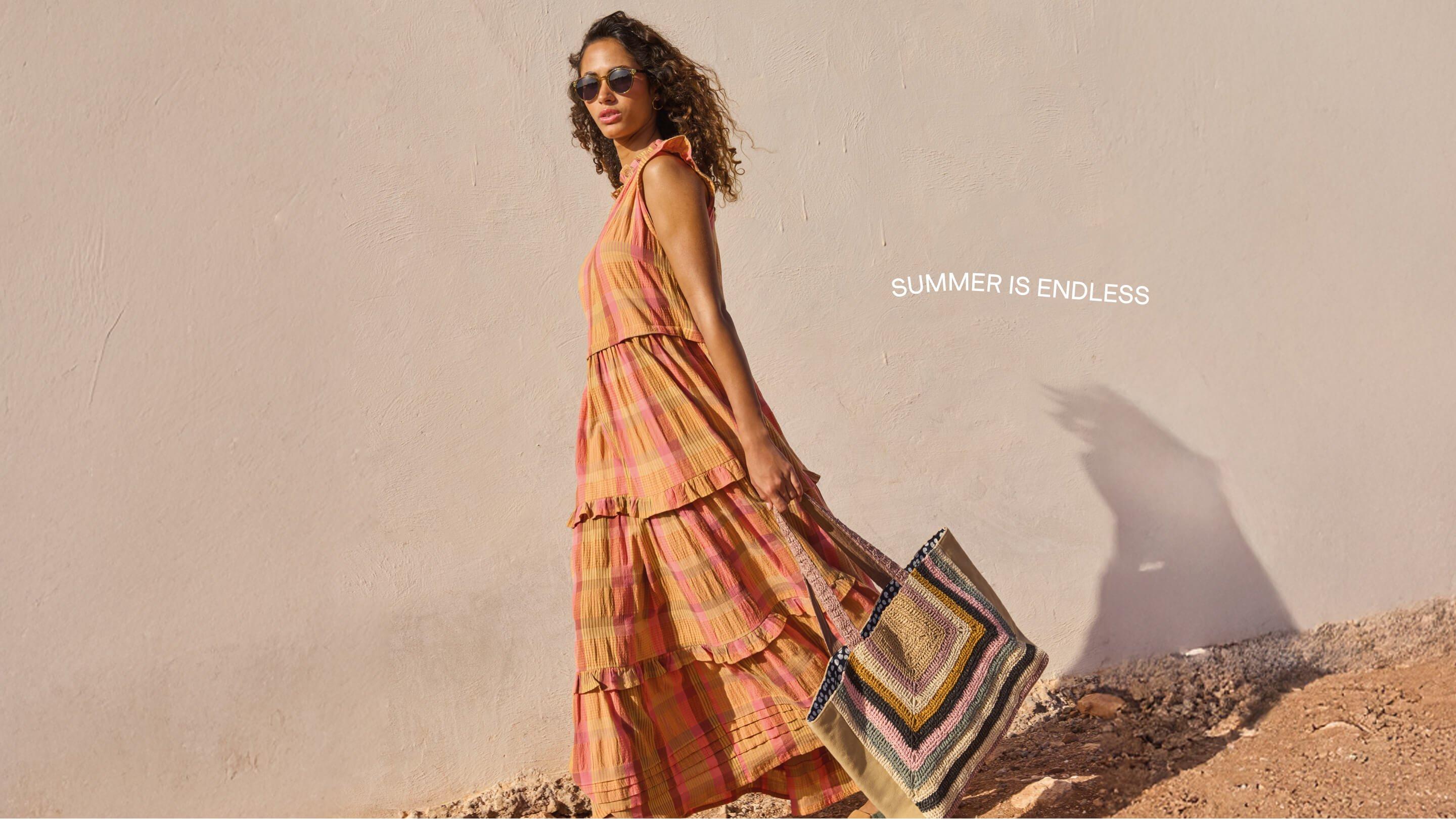 a woman in a long dress carrying a bag