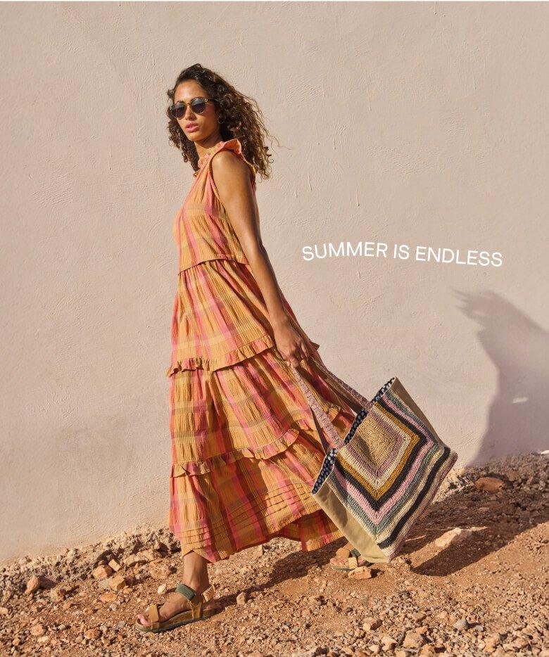 a woman walking with a bag and a dress