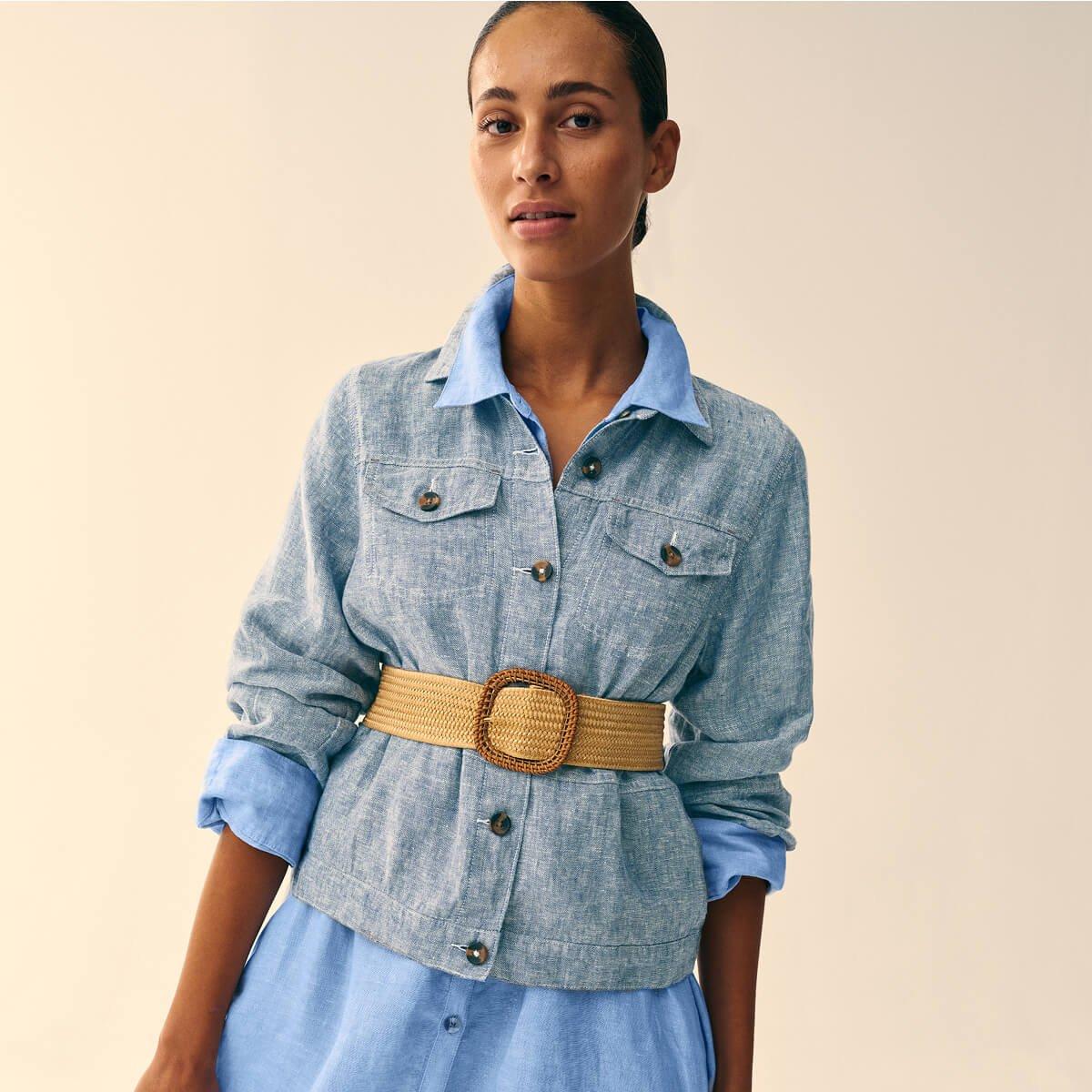 a woman in a blue linen dress and a belt standing up