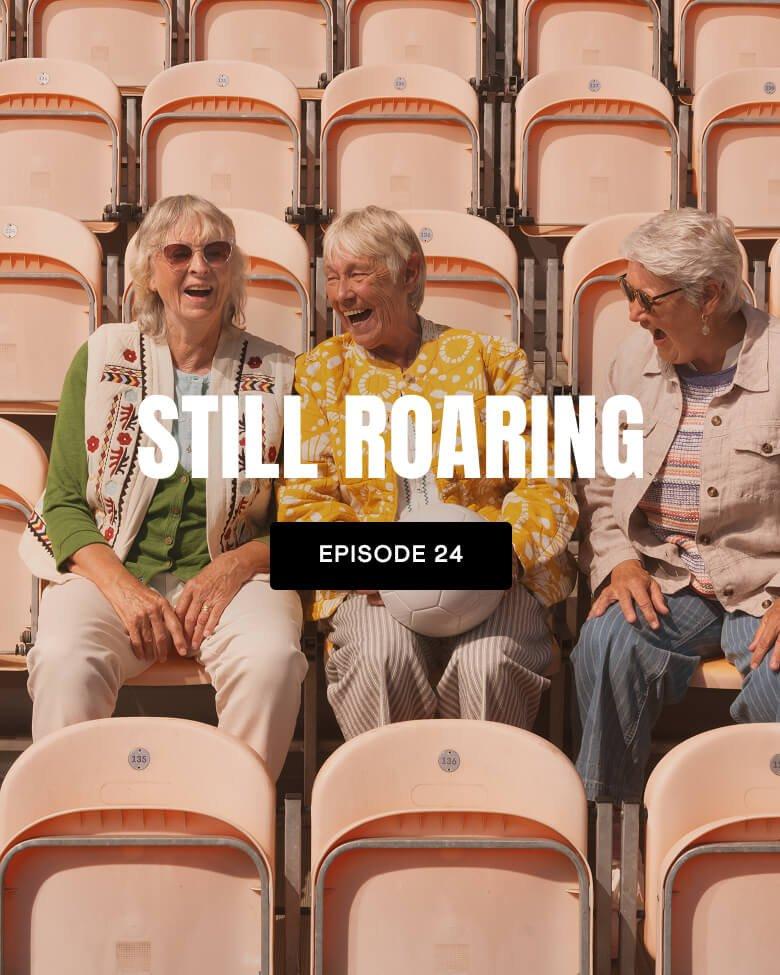 three women sitting in a row of empty seats with a caption reading still roaring