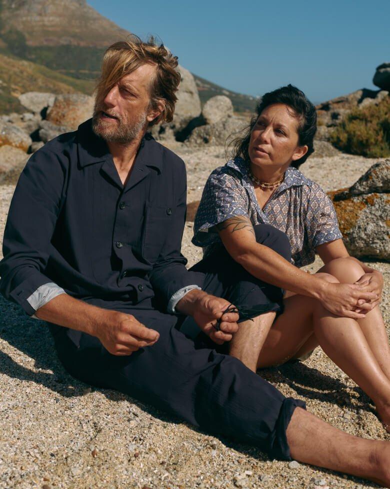 a man and woman sitting on the ground next to each other
