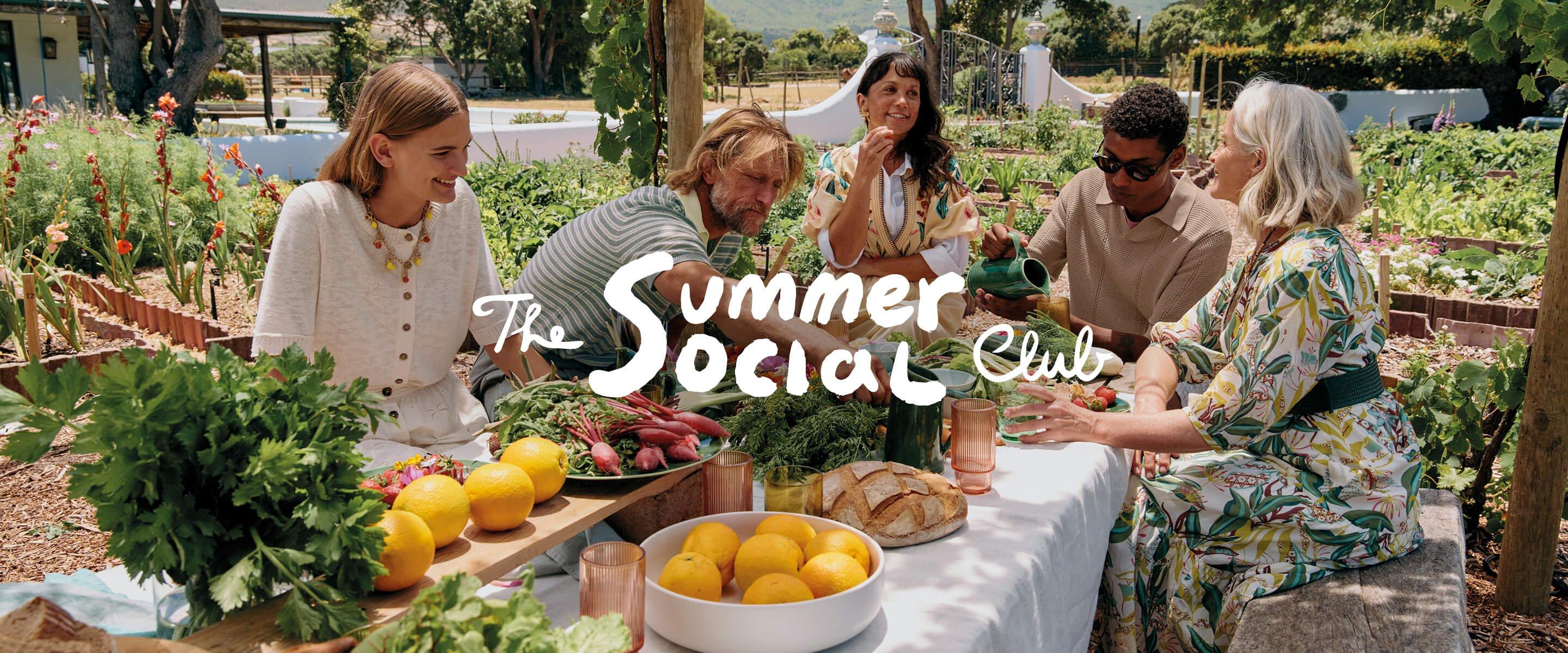 a group of people sitting around a table with food