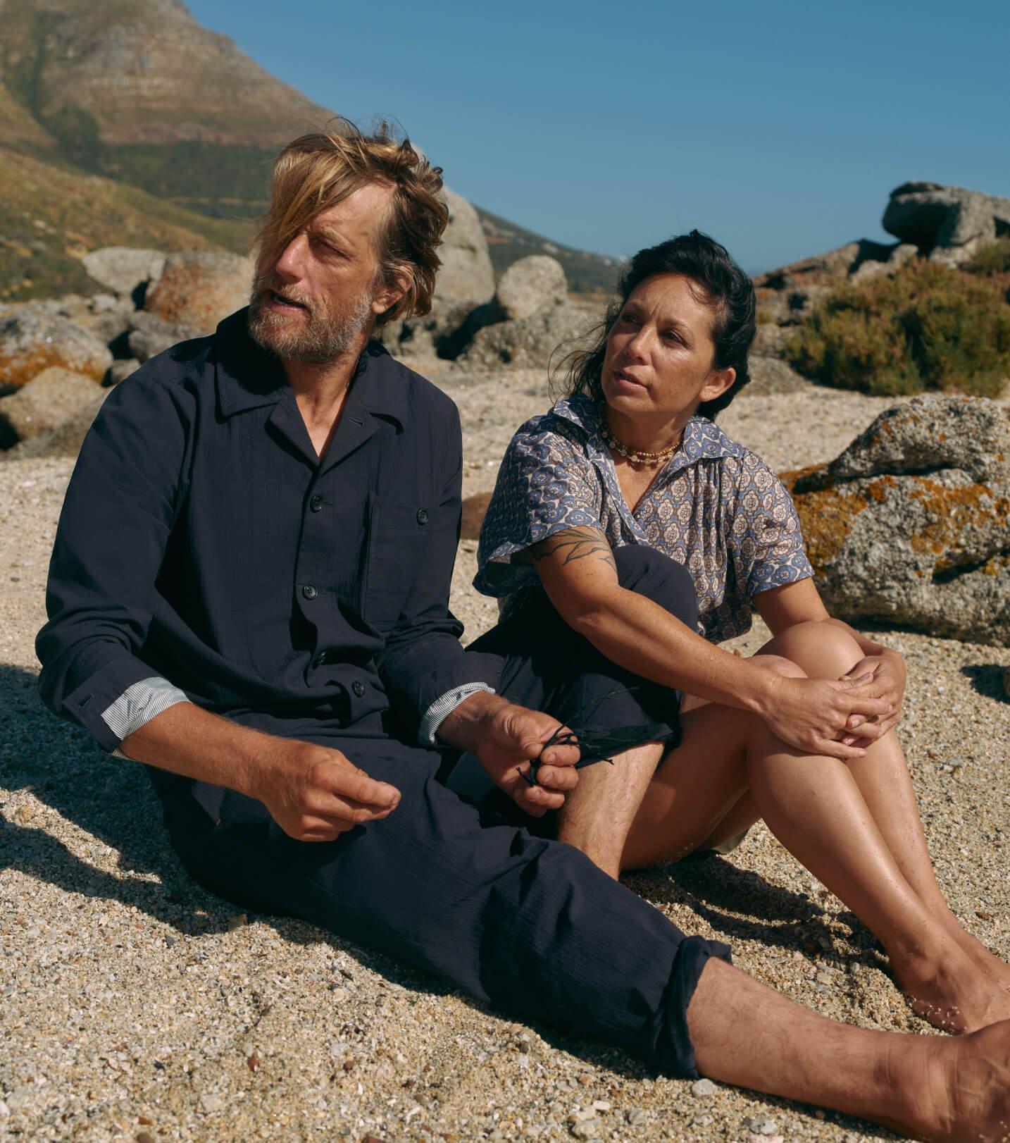 a man and woman sitting on the ground next to each other