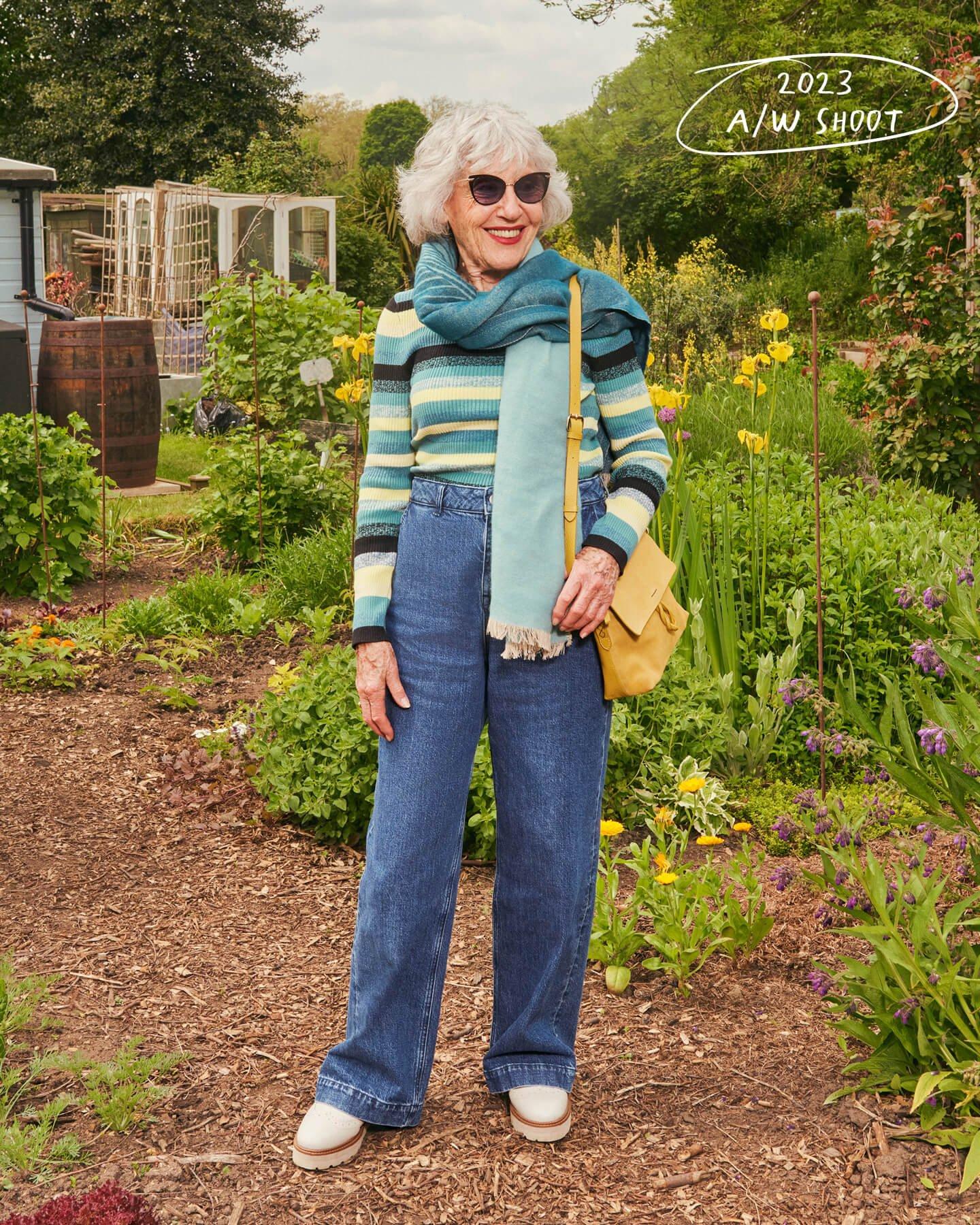 a woman in a garden with a scarf and sunglasses wearing White Stuff