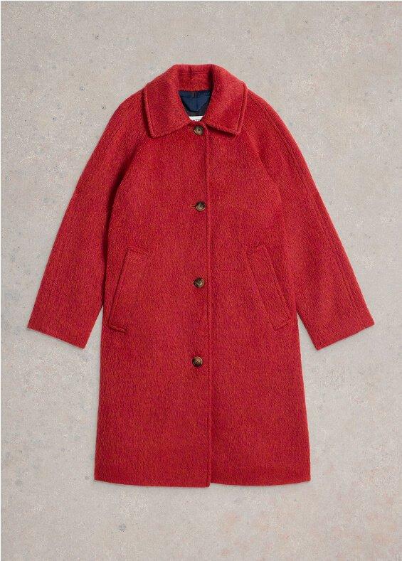 a red coat that is sitting on a concrete floor