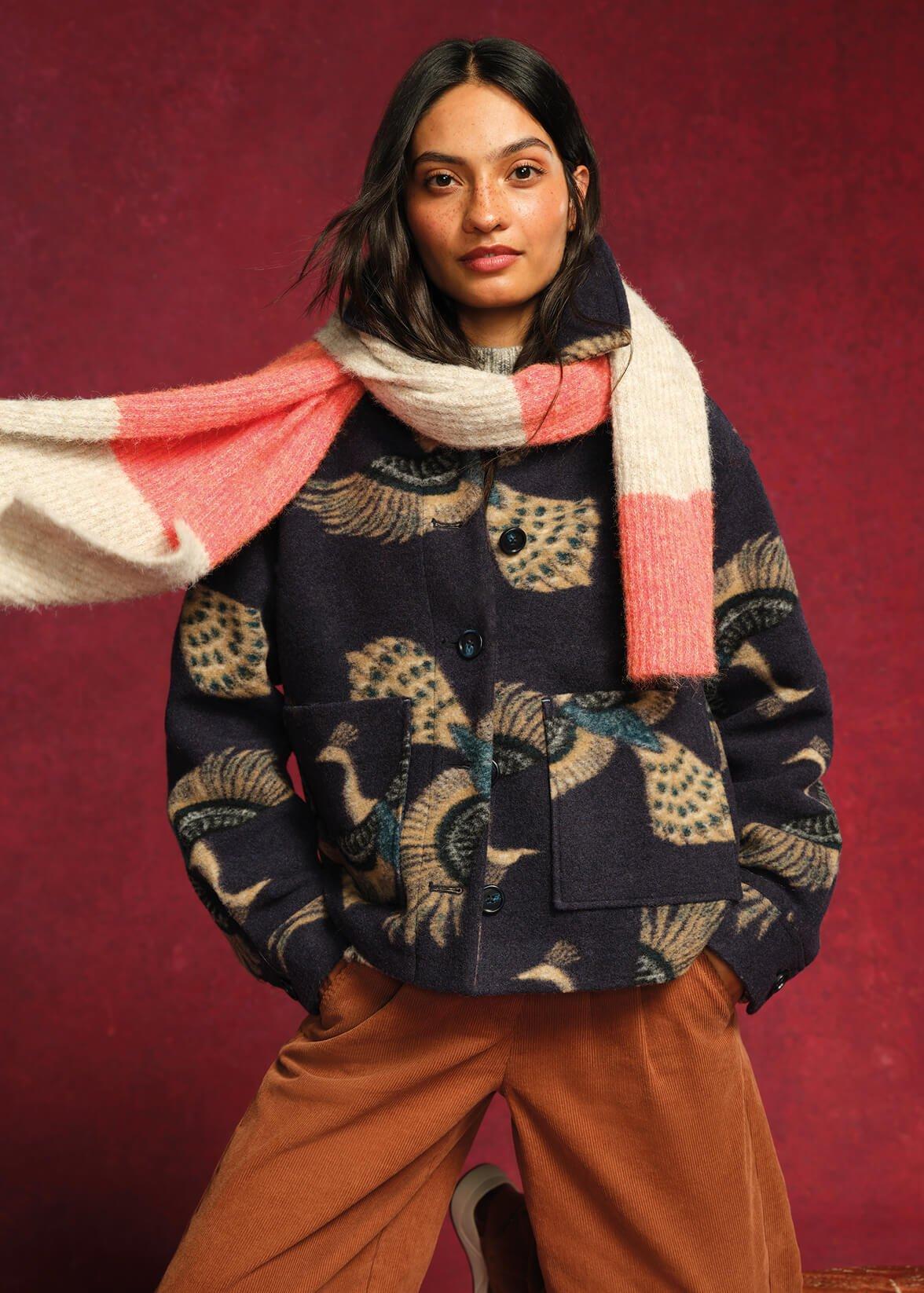 a woman in a jacket and scarf posing for a picture