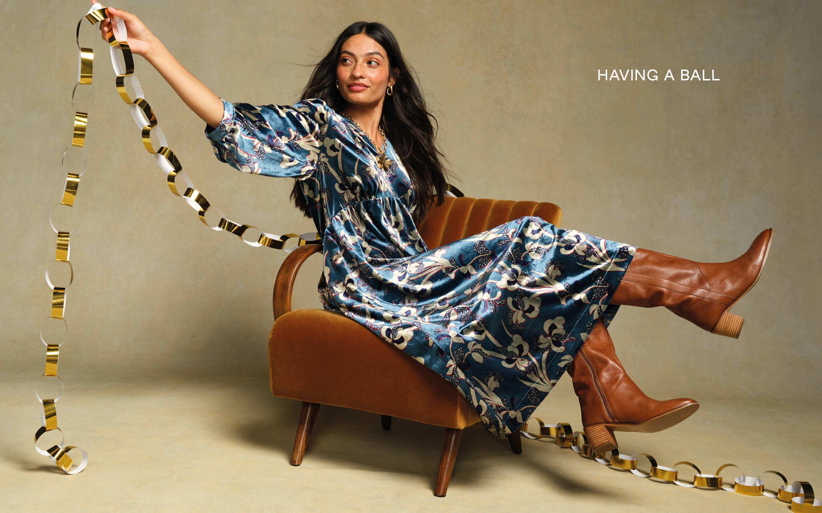 a woman sitting on a chair with a ribbon around her waist