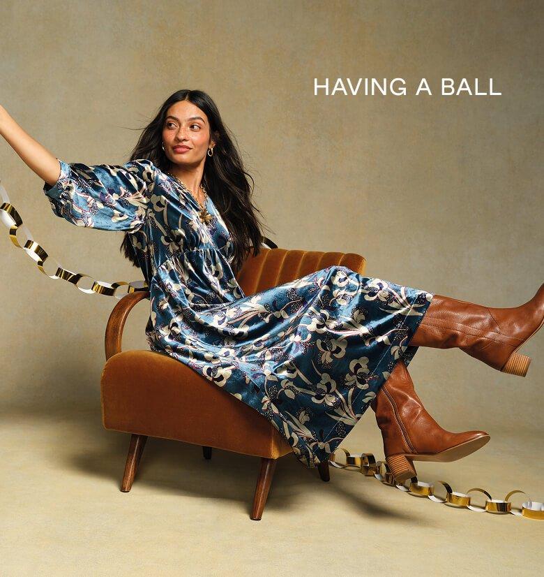 a woman sitting on a chair with a ribbon around her waist