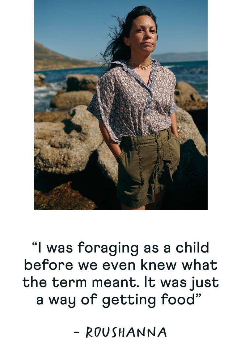 a woman standing in front of a rock with a quote on it