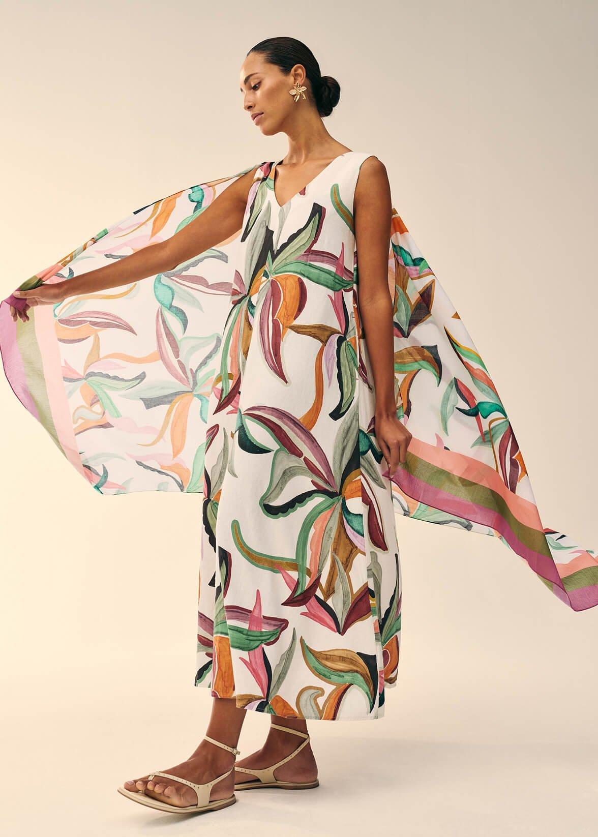 a woman in a dress with a cape and a flower print