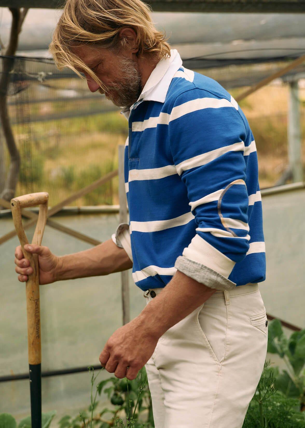 a man in a blue and white striped shirt holding a shovel