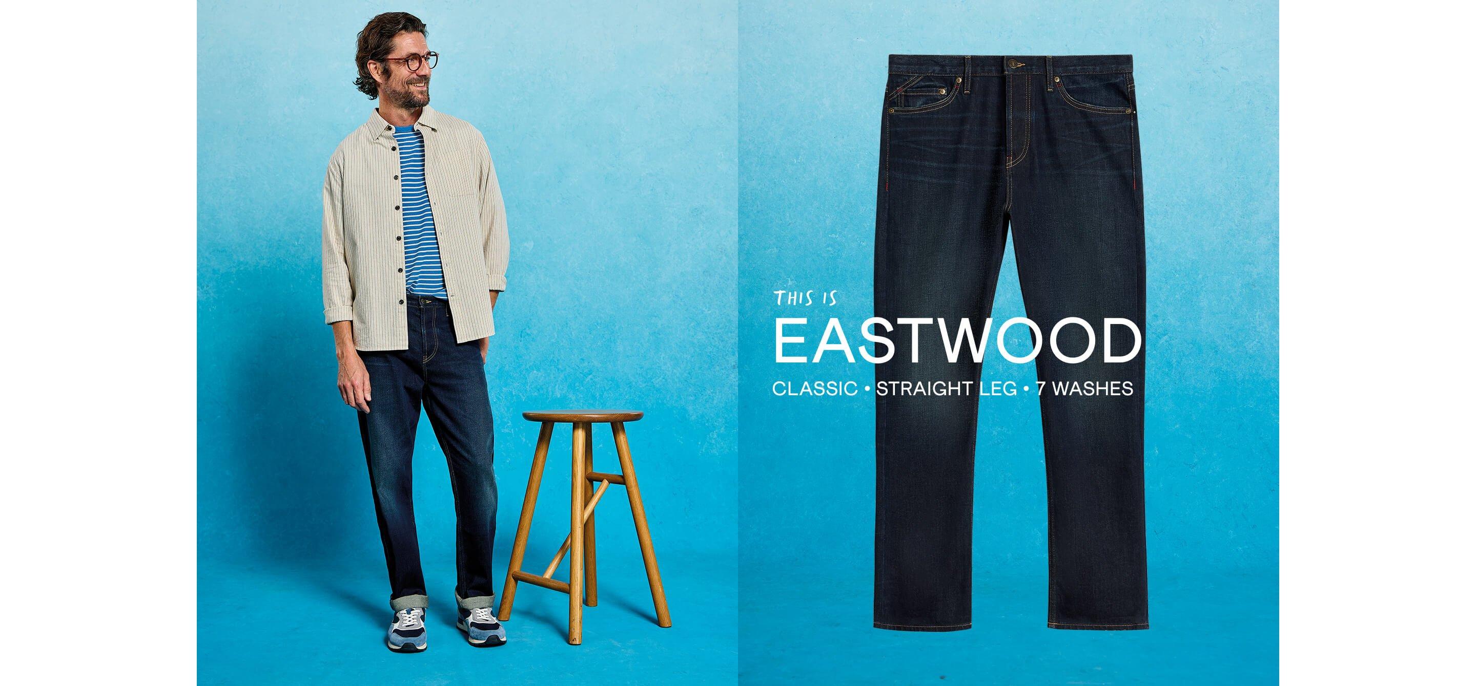 a man is standing next to a stool and wearing a pair of jeans