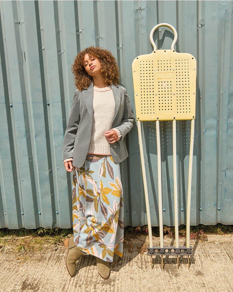 a woman leaning against a wall with a large metal object
