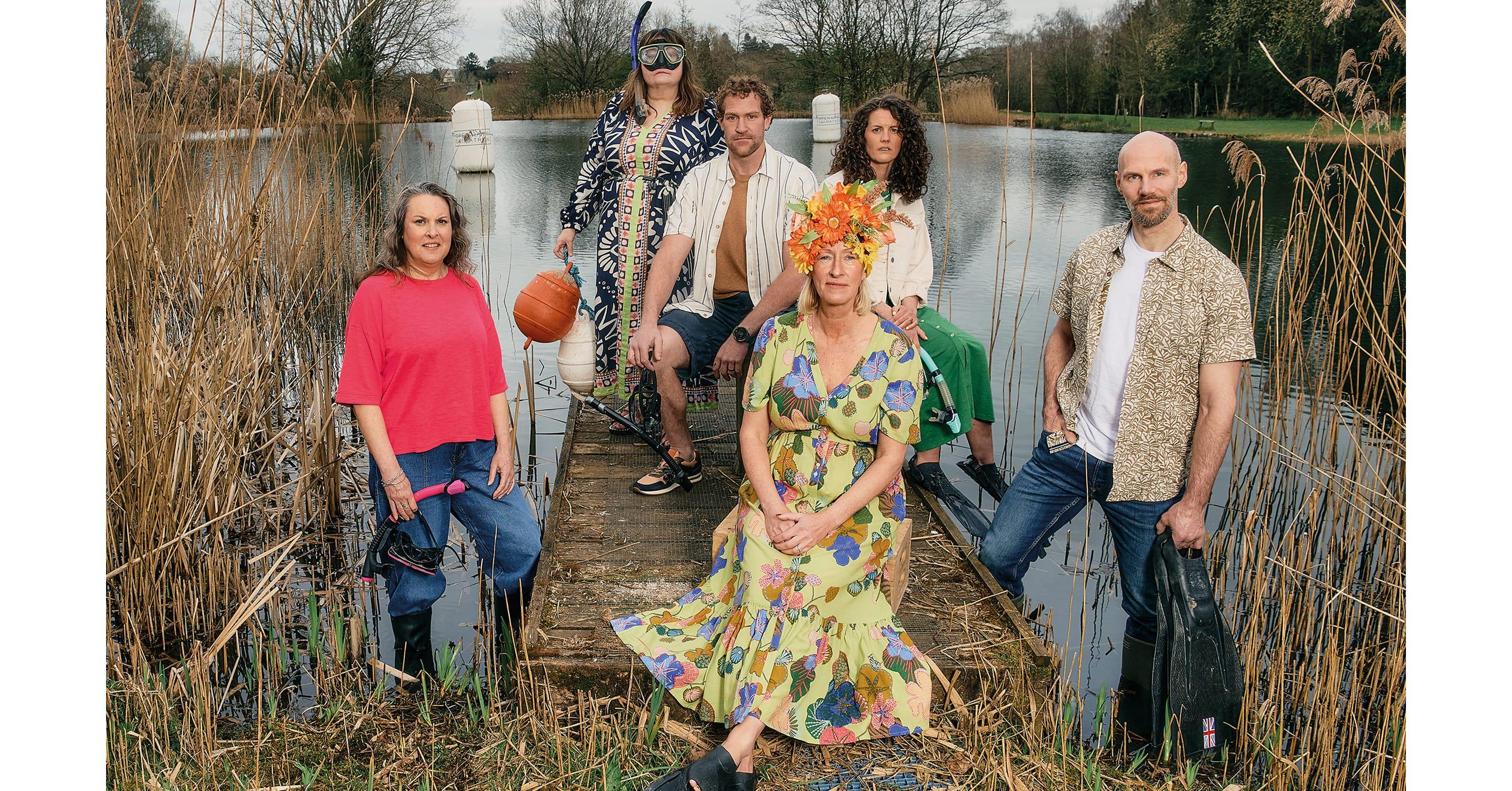 a group of people standing on a dock near water