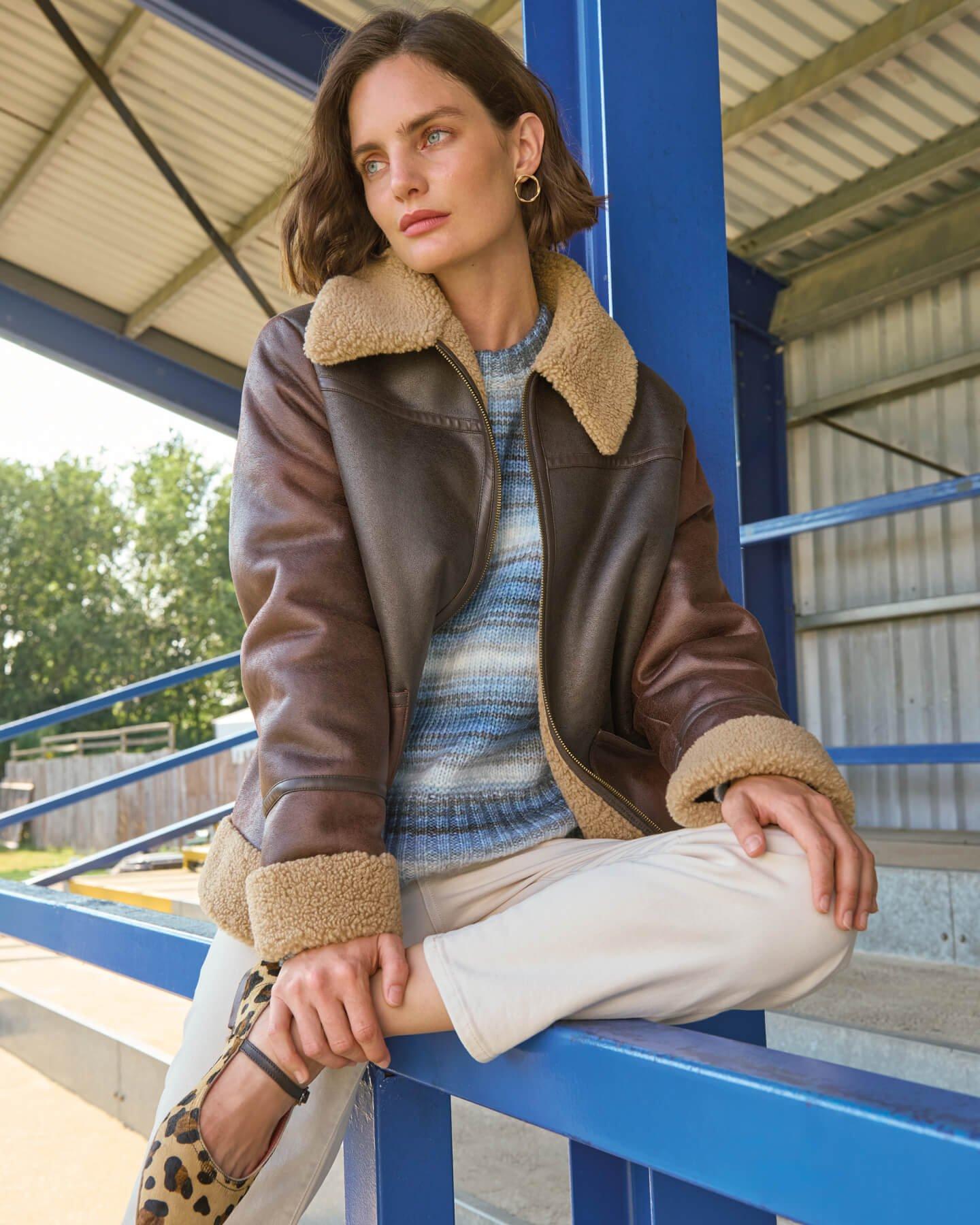 a woman in leopard print shoes sitting on a railing