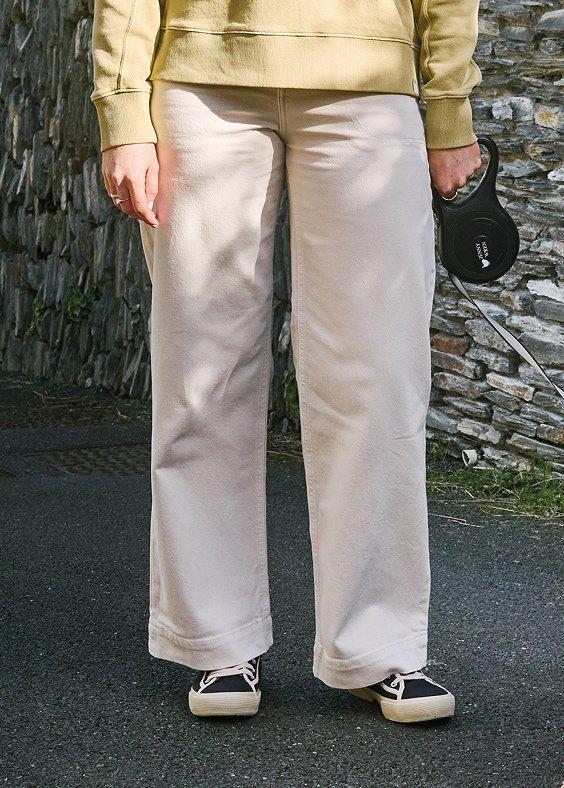 Woman's legs in jeans in front of stone wall