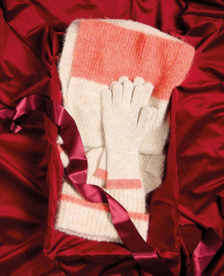 a red satin bag with gloves and a red ribbon