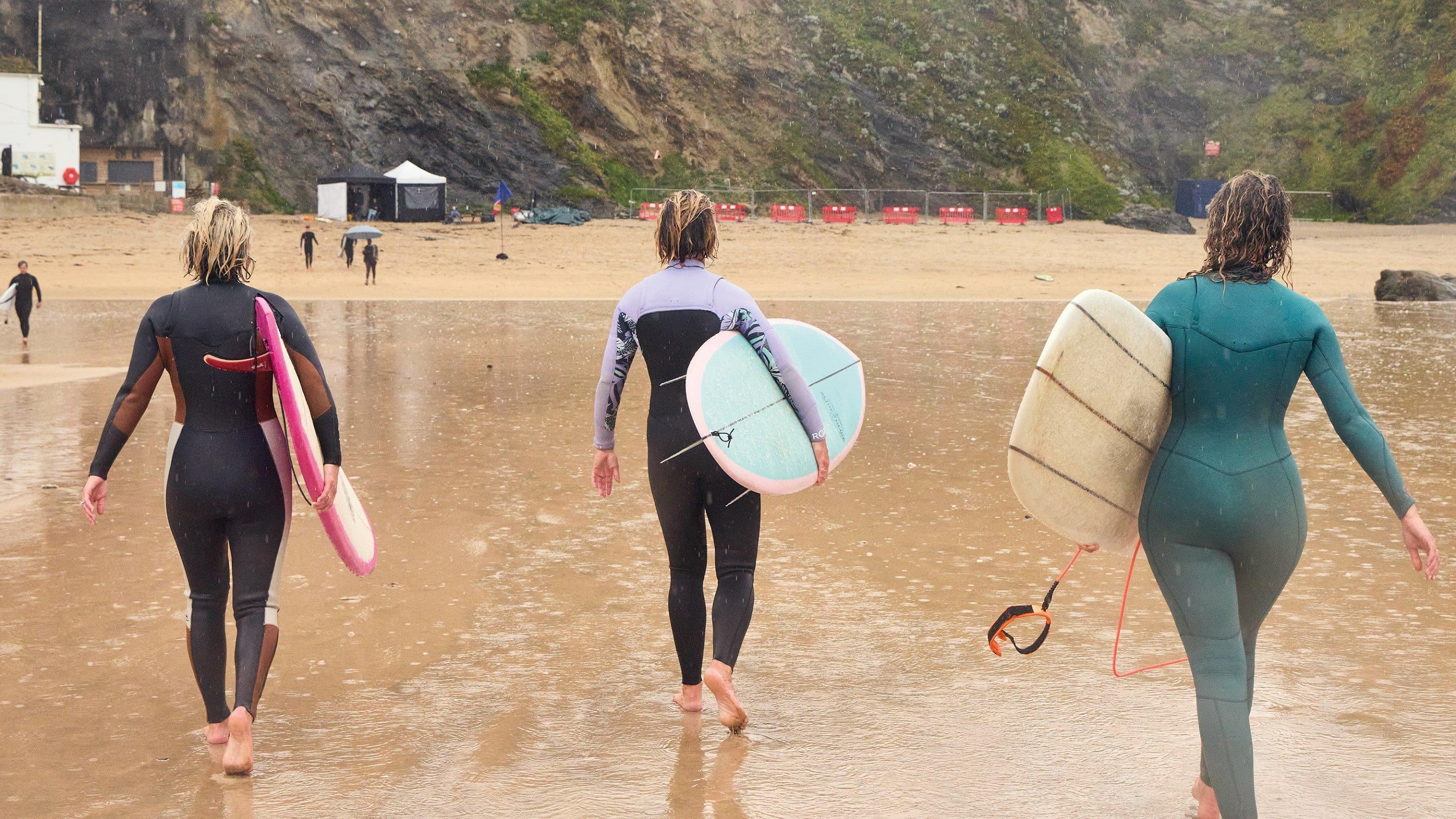 women walking with surfboards