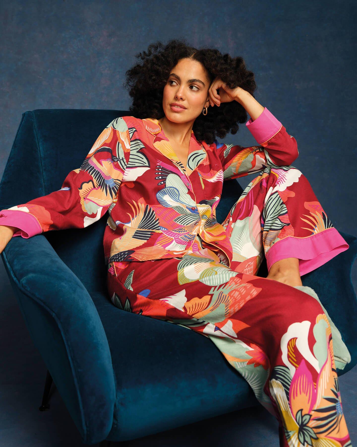 a woman in a colorful pyjama set sitting on a blue chair