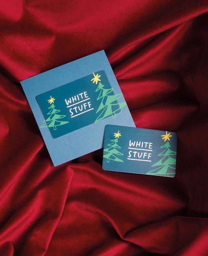a white stuff gift card on a red cloth with a white stuff logo