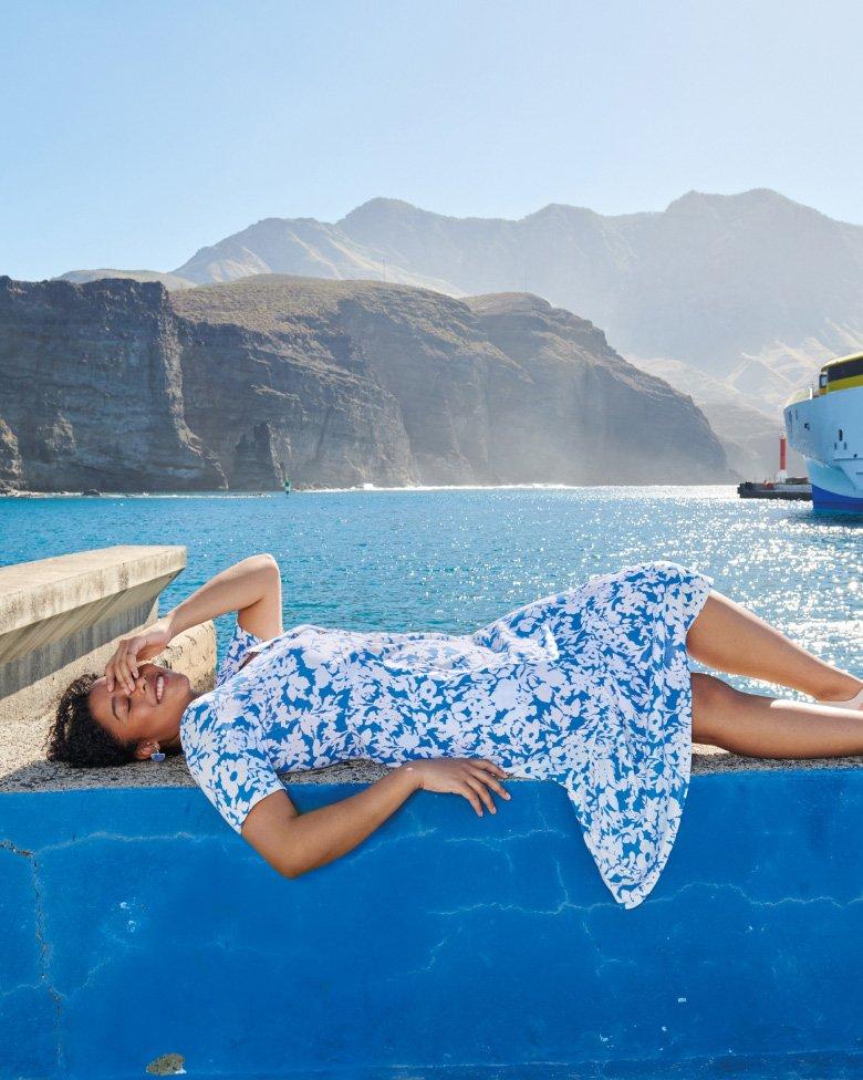 woman lying down in blue pattern summer dress
