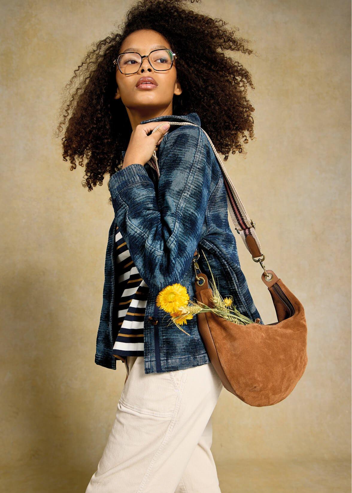 a woman weating a jacket and a bag.