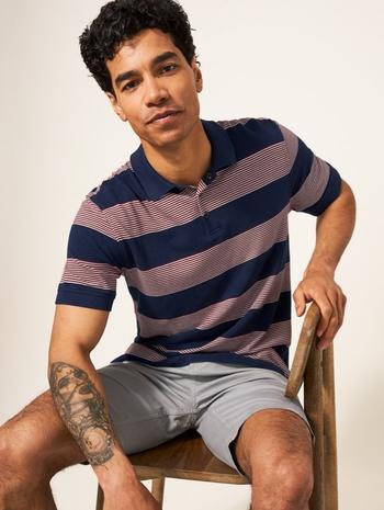 a man sitting on a chair with a tattoo on his leg