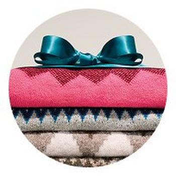 a stack of colorful blankets with a blue bow