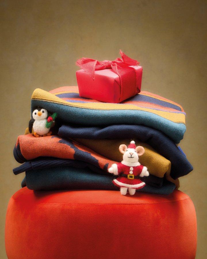 a pile of folded clothes sitting on top of a red stool