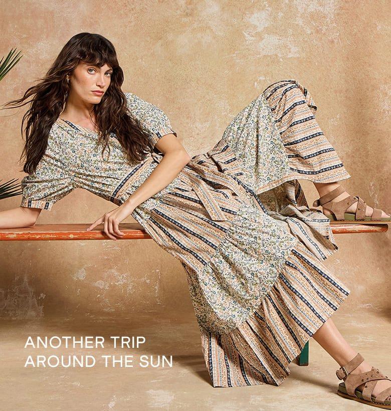 a woman in a dress sitting on a bench with a caption that reads Another trip around the sun