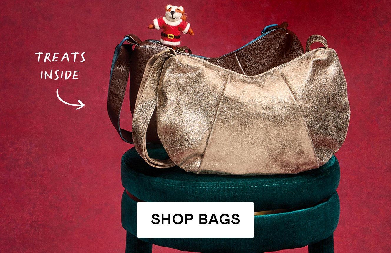 2 bags on a teal velvet chair with a red background. Text is "treats inside". Click here to shop bags. 
