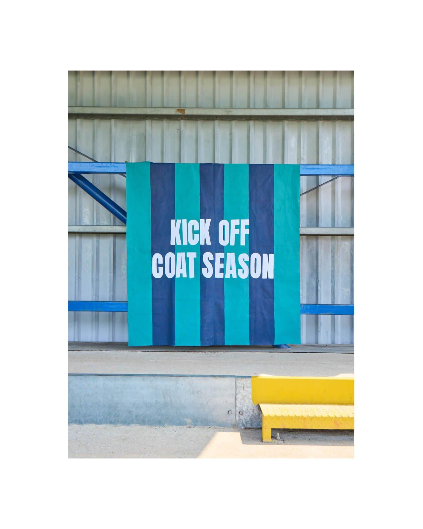 a banner that says, "Kick off coat season" hanging on a wall