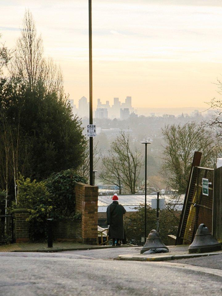 a person walking down a street with a city in the background