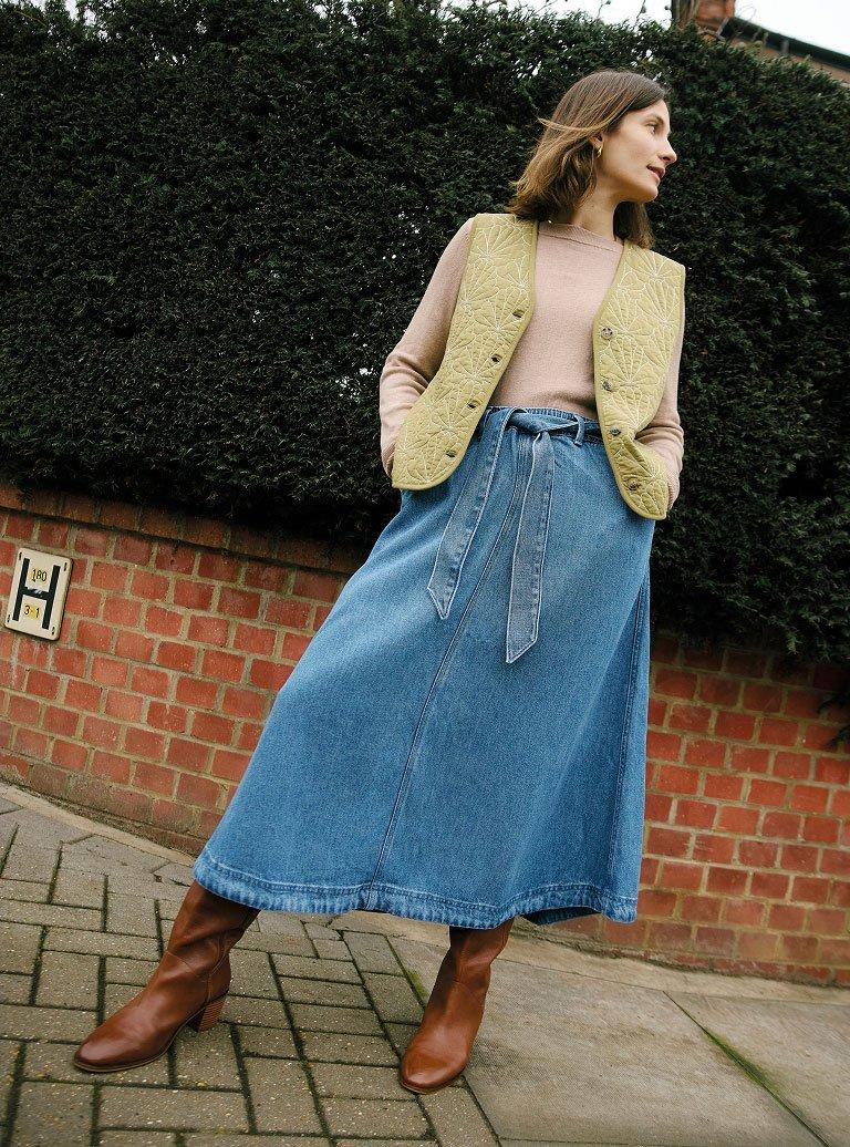 Woman in denim skirt and gilet