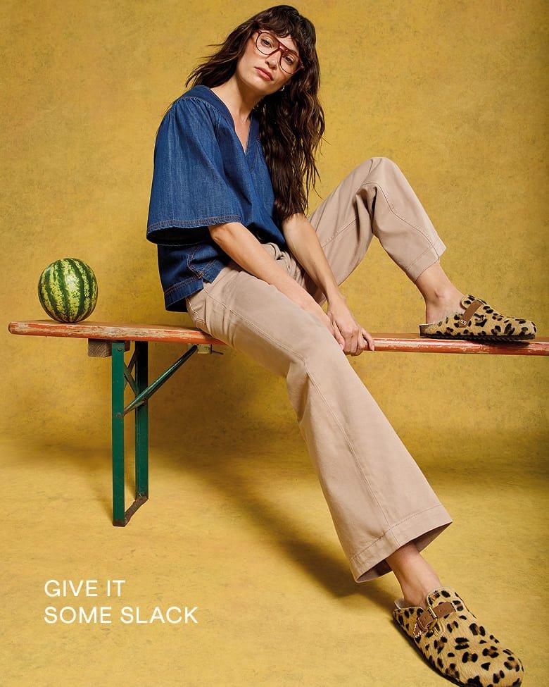 a woman sitting on a bench with a watermelon 