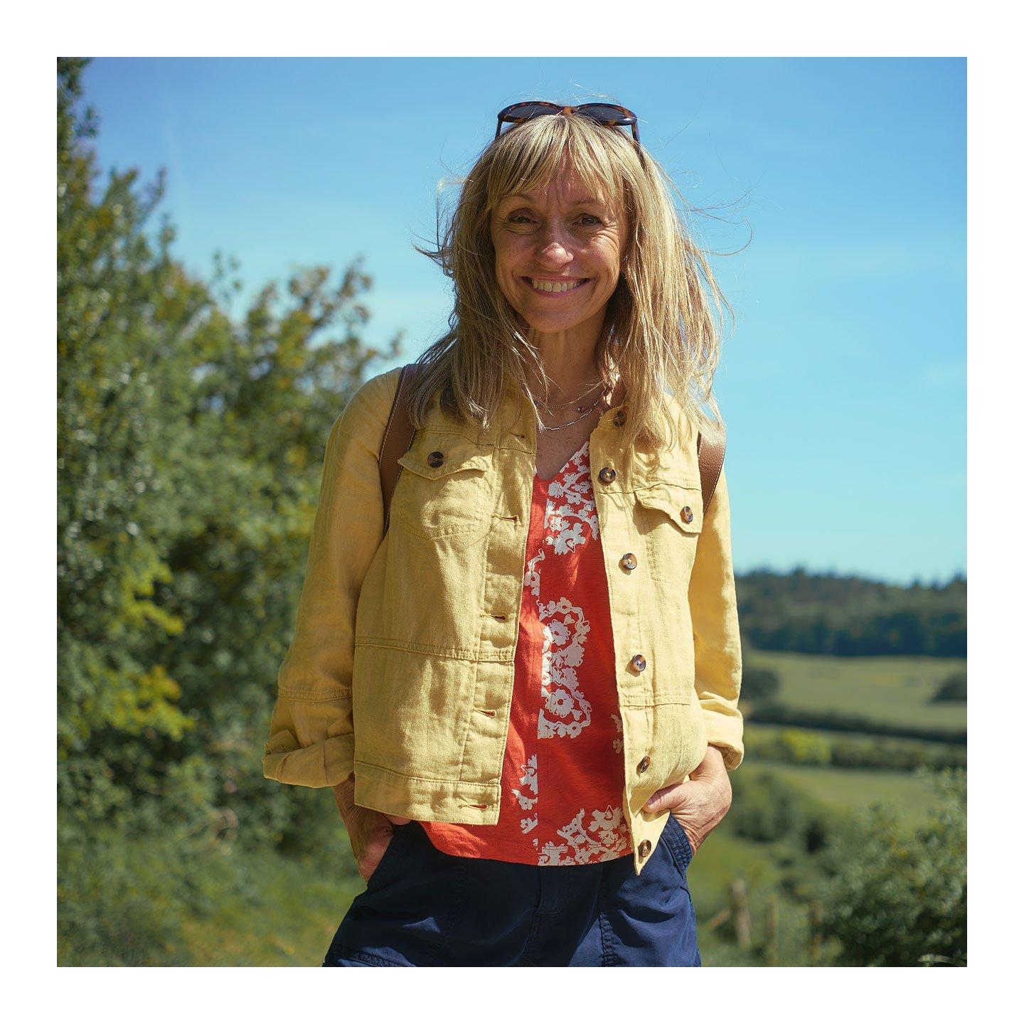 a woman standing in a field with a smile on her face