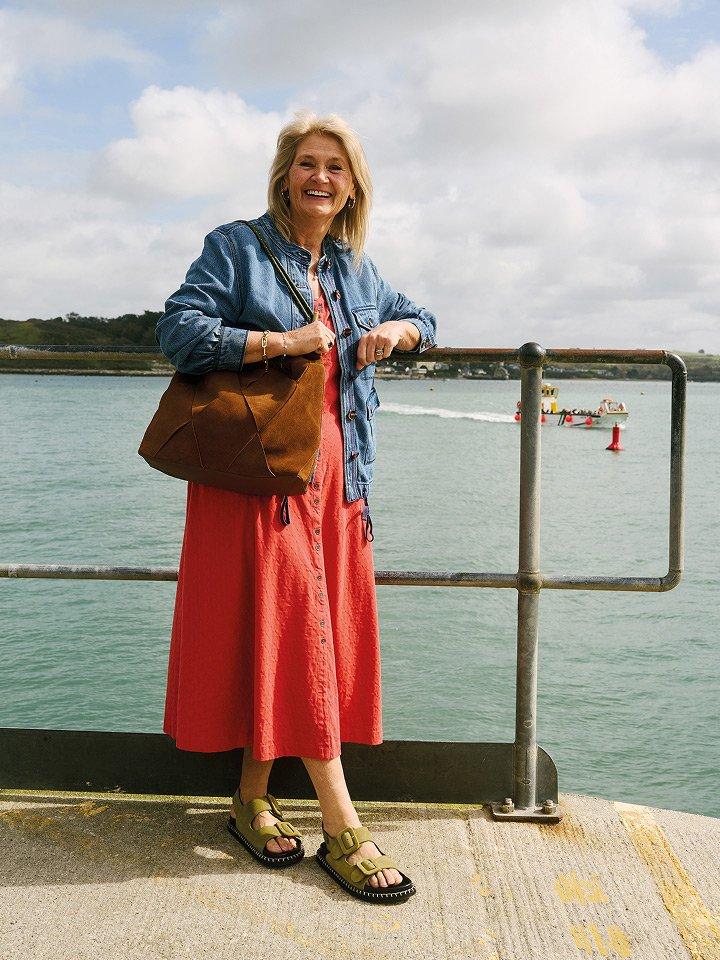woman in red dress standing by seaside