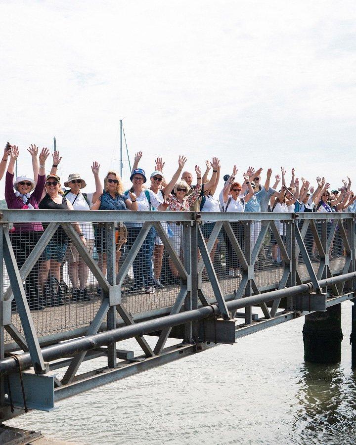 a group of a group of people on a bridge waving their hands