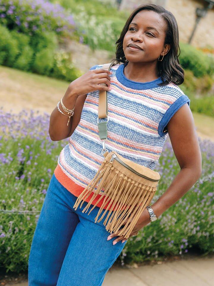 a woman in a knitted White Stuff tank top standing outside in front of lavender plants