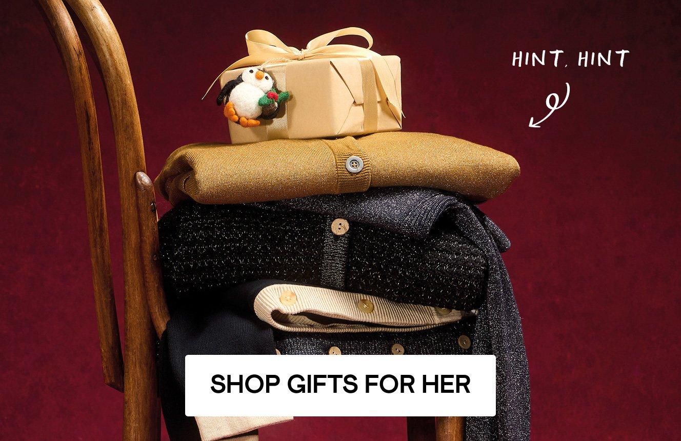 A stack of jumpers, Christmas decorations and gift boxes, Click here to shop gifts.