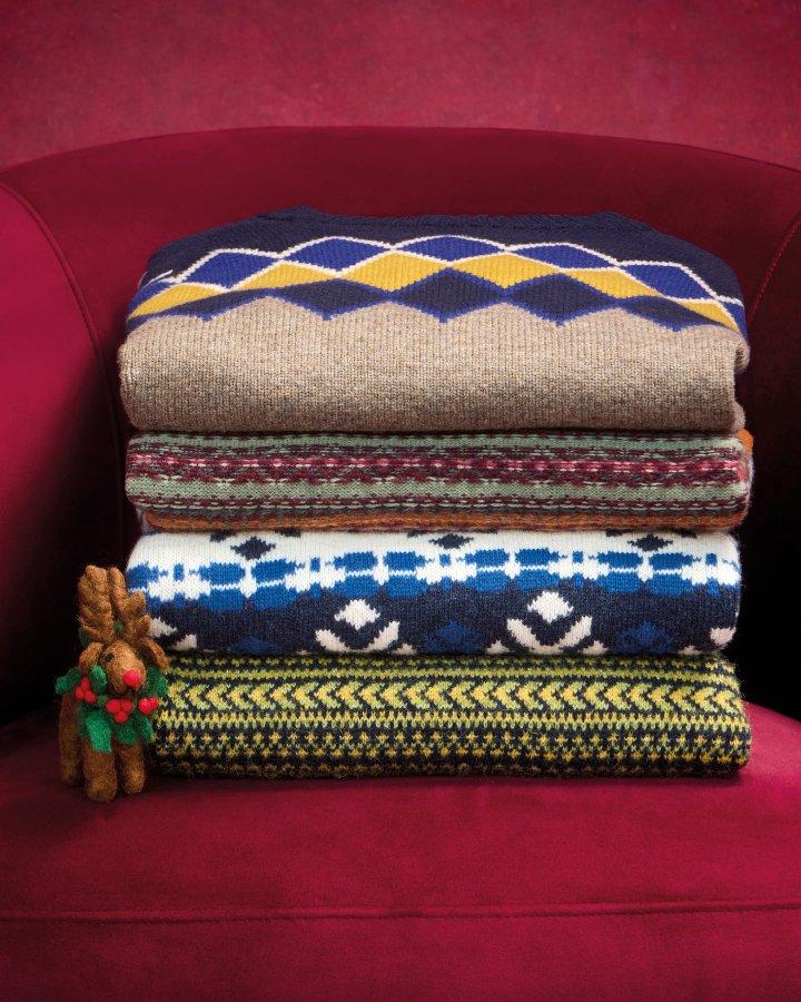 a stack of sweaters on a red chair with a small toy