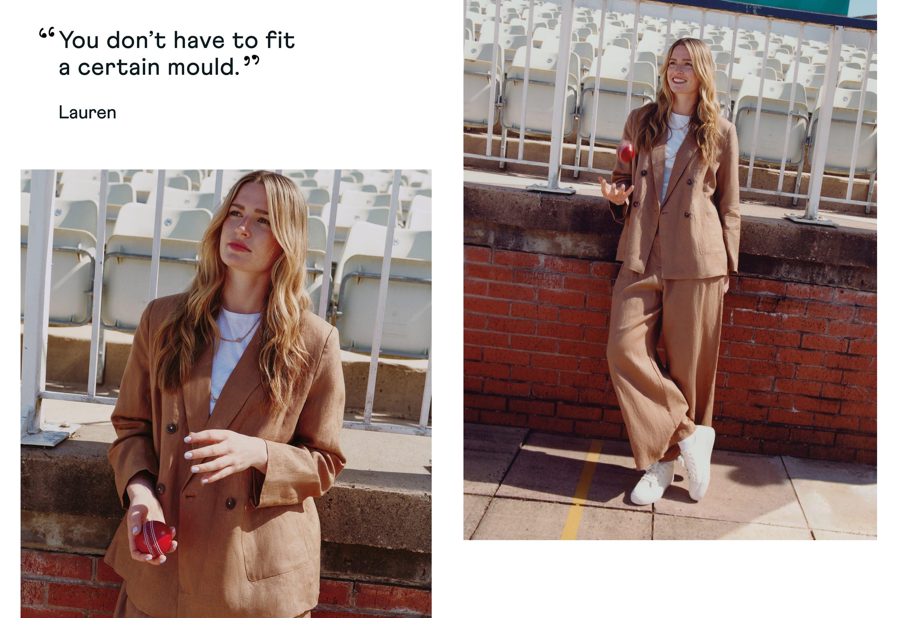 a woman in a brown suit standing next to a brick wall