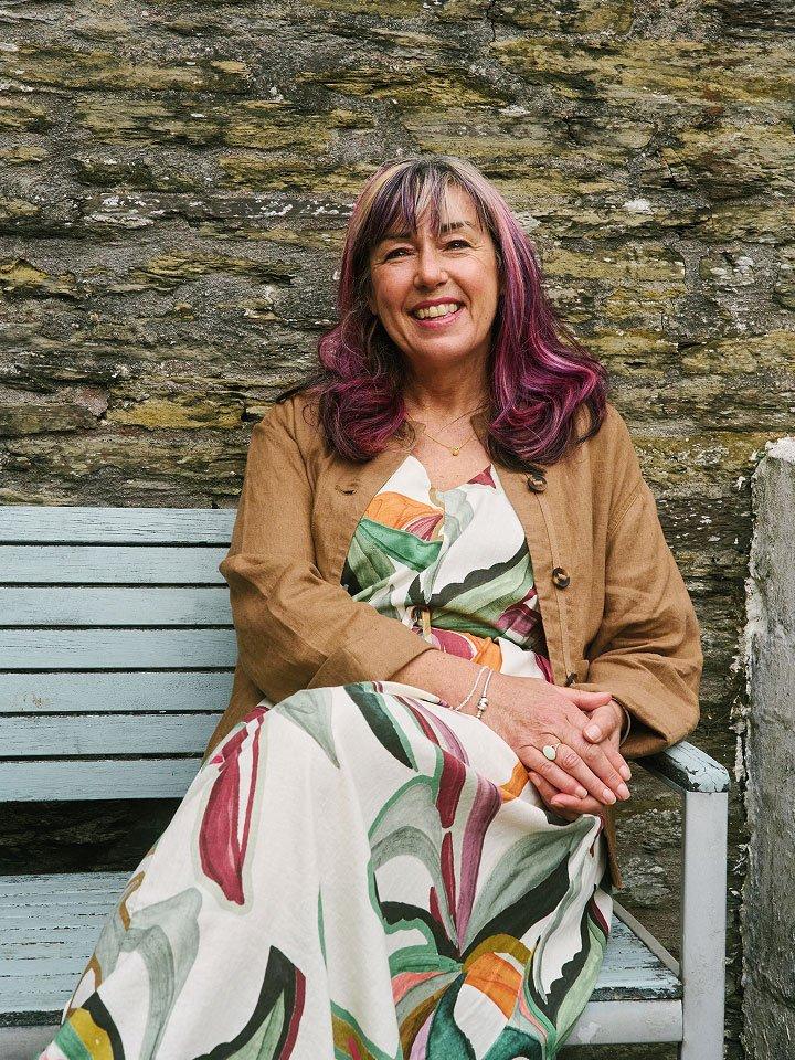 woman in printed dress sitting on bench