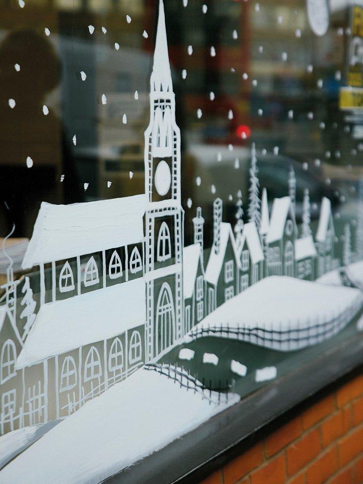 a window display with a church and a town in the background