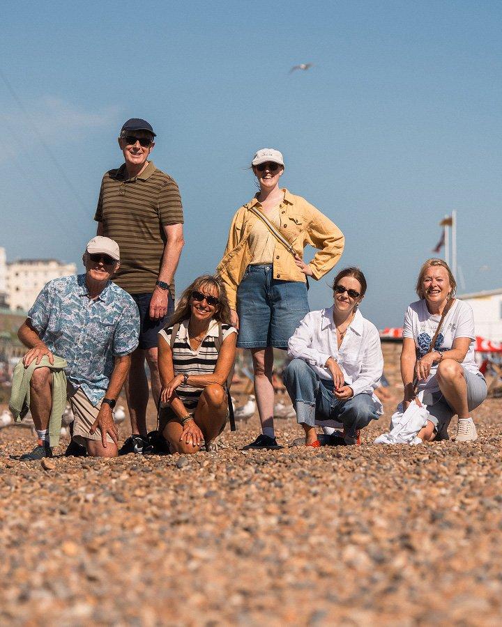 a group of people are posing for a picture on a beach