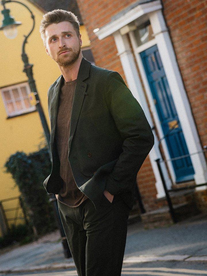 a man in a suit standing on a street corner