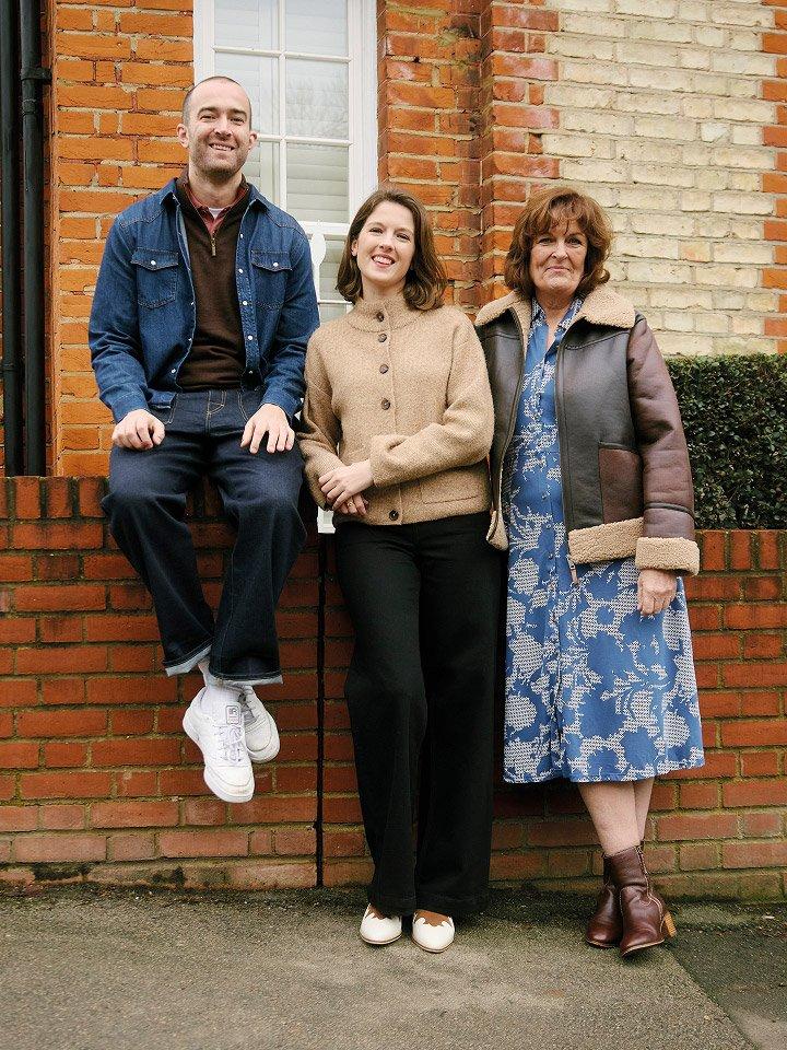 a group of three people standing on a brick wall