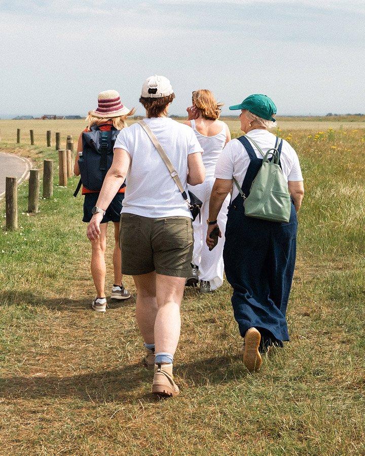 a group of people walking down a road with a sign in the distance