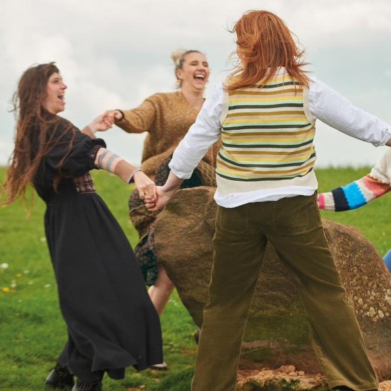 women dancing around an ancient stone