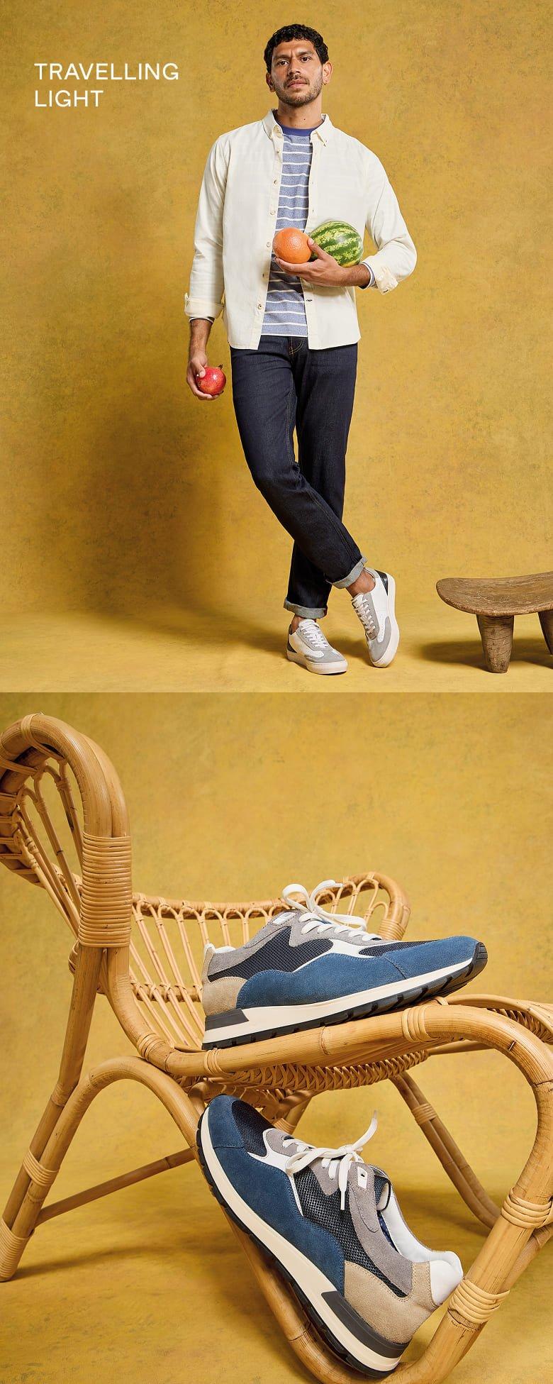 a man in a shirt and white shoes standing next to a chair with a pair of sneakers